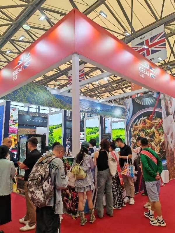 GB trade stand in exhibition hall with red carpet and people looking at display